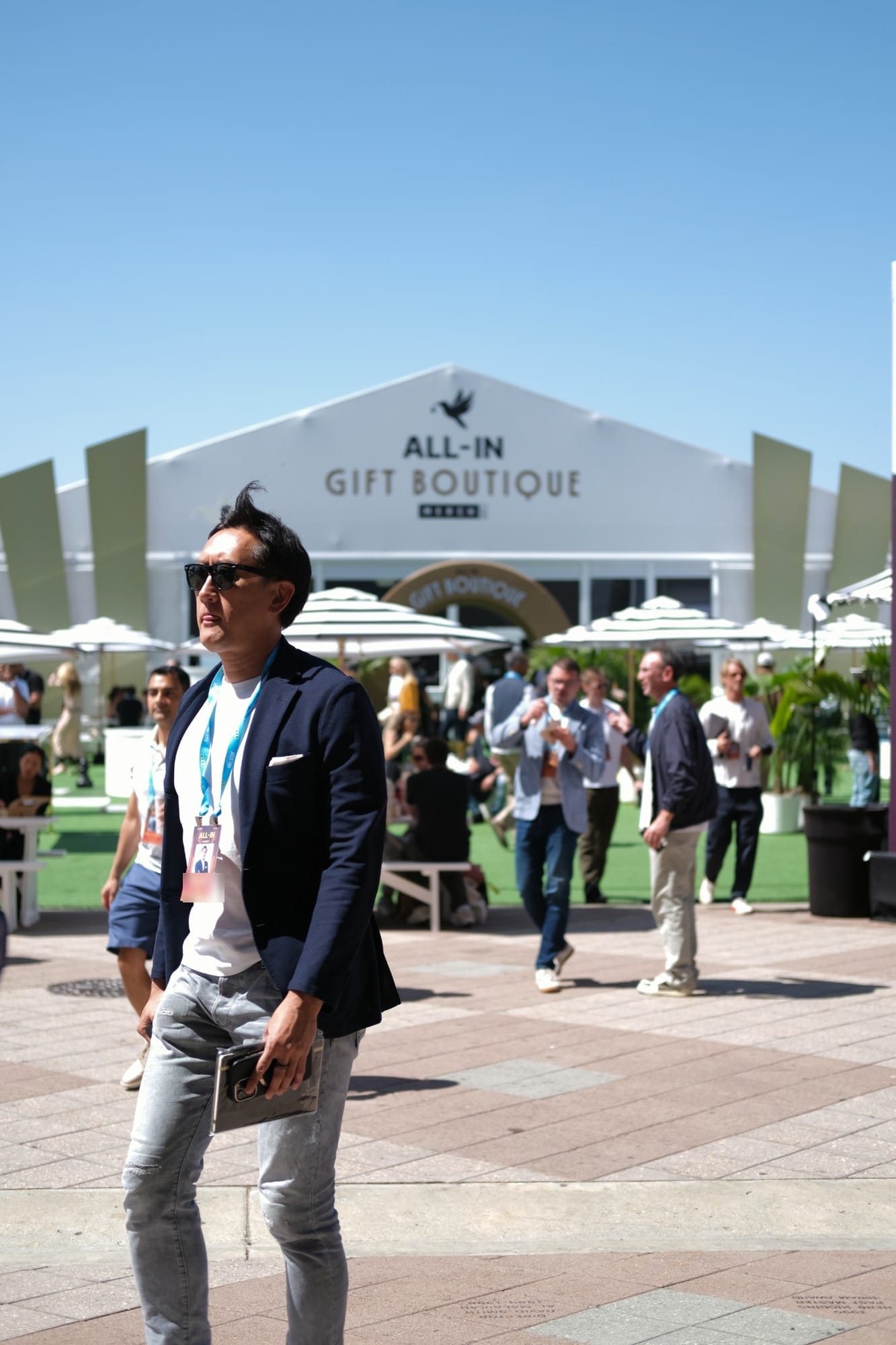 An attendee in sunglasses walking past the summit gift boutique tent